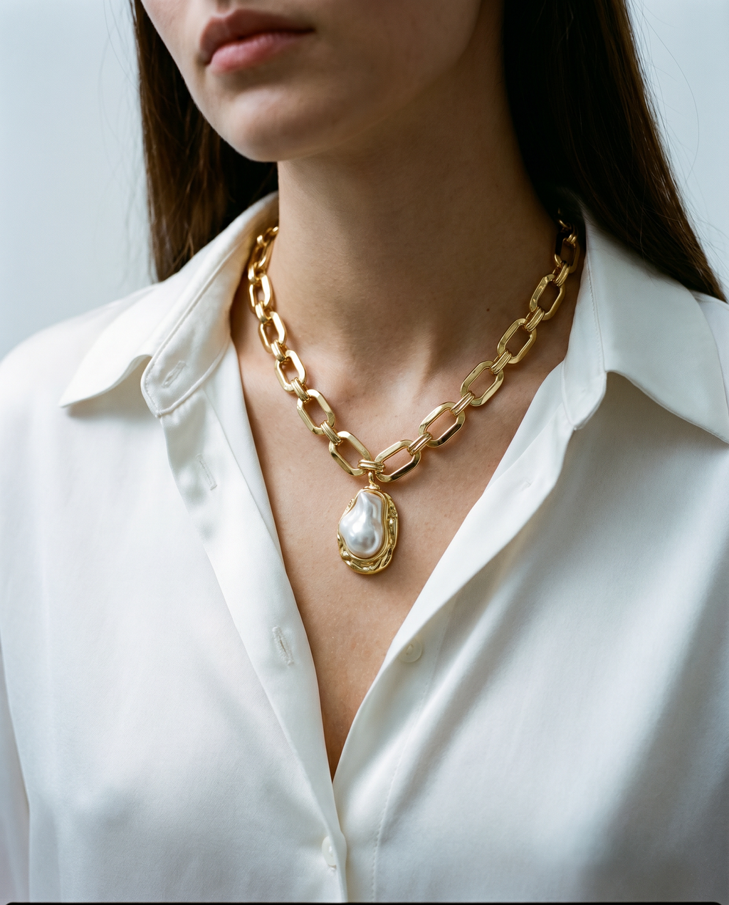 Collier BAROQUE à larges maillons dorés et perle baroque, porté sur une chemise blanche – Mad About