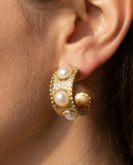 Boucles d’oreilles MARA dorées portées, gros plan – Mad About